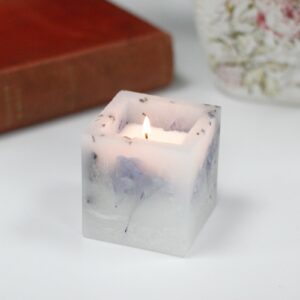 Small square Soya candles with flowers. Luxury enchanted glowing candle